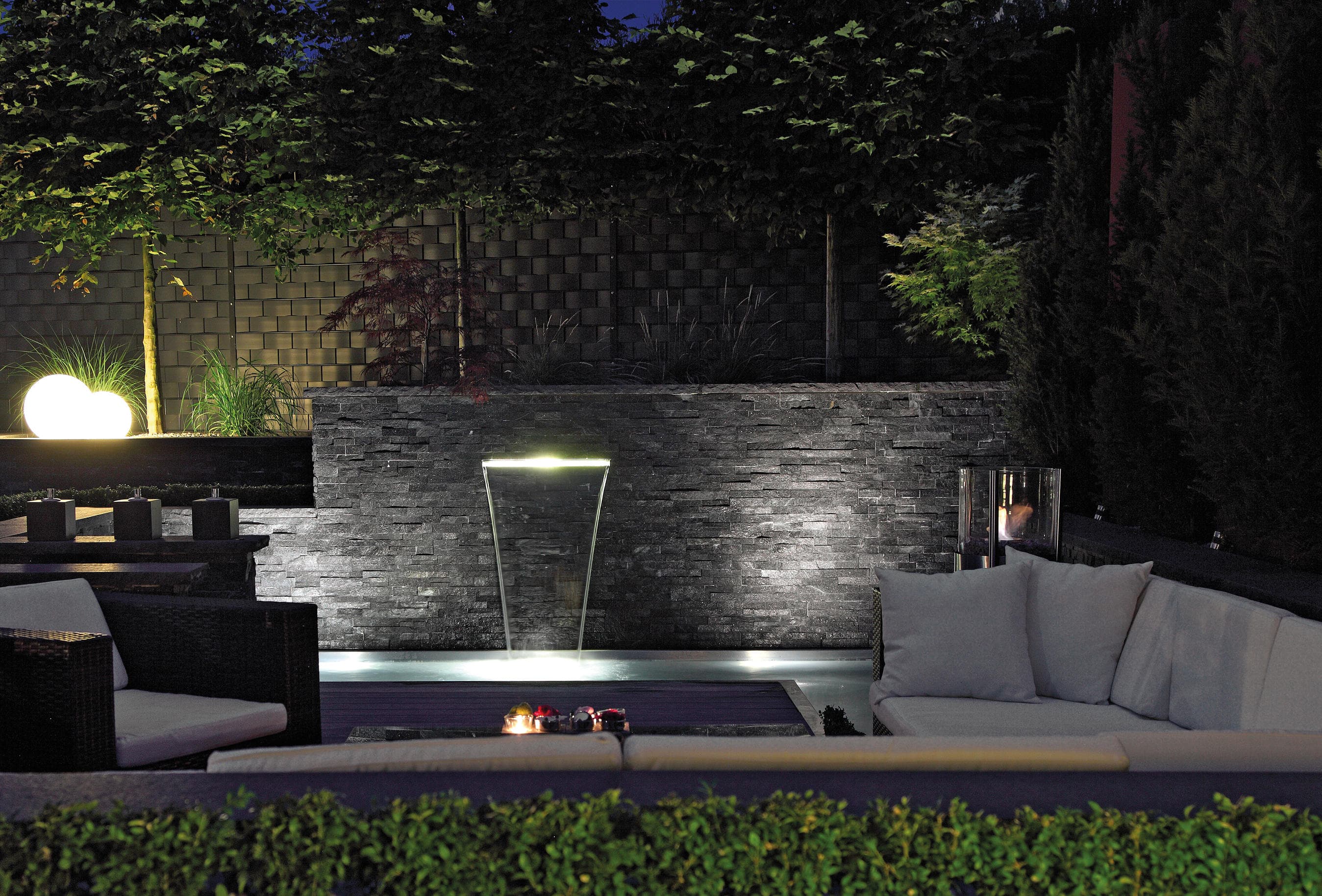 Elegant evening garden with water feature and ambient lighting